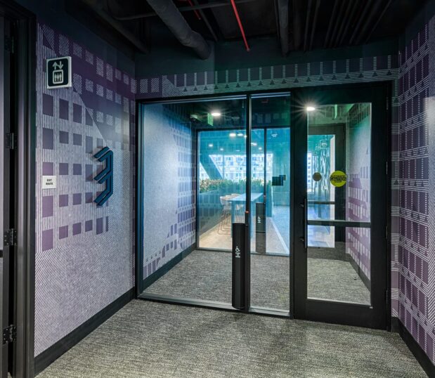 Hallway to atrium with custom wallcovering in plum.