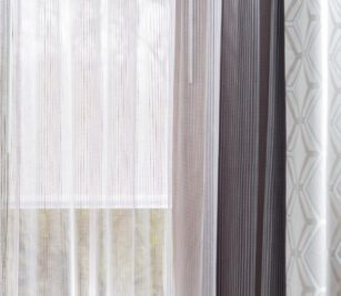 Shown here is a custom drapery project with sheers with textural vertical stripes and drapes with a hexagon pattern in ivory taupe and grey.