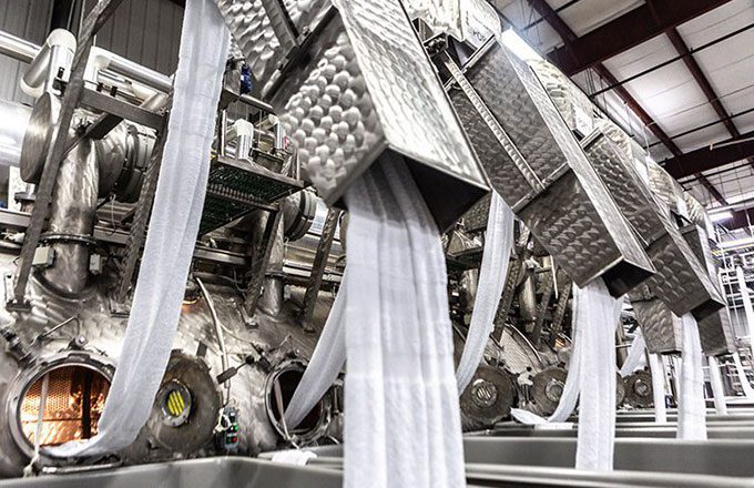 A large machine used to pre-launder long stretches of uncut, unfinished linens.
