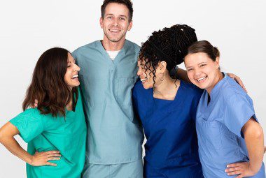 A group of nurses huddled together talking and laughing.