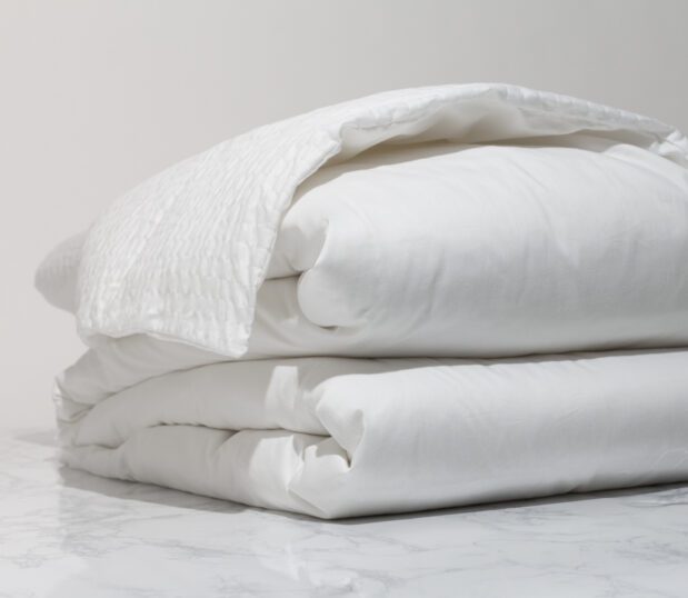 A folded Cumulus no iron duvet cover showing both the Cumulus face and the Centium Satin back.