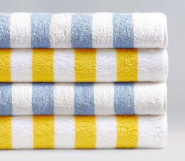 A stack of blue and yellow cabana stripe pool towels.