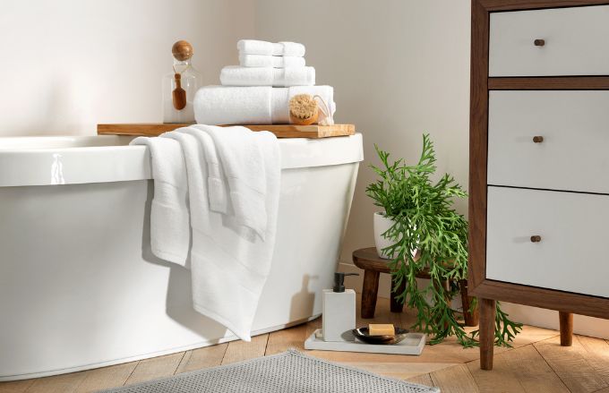 Stack of Lynova white towels in bathroom