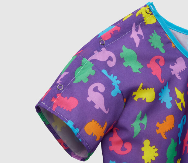 A close up image of our DinoDreams purple pediatric gown.